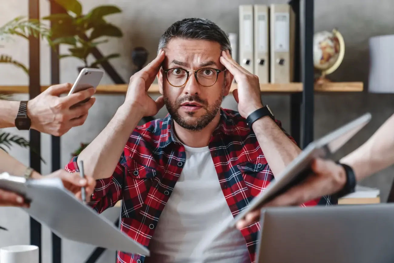 Homem em situação de estresse lidando com várias pessoas falando com ele ao mesmo tempo